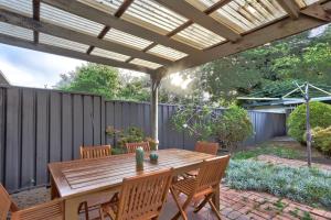 a wooden table and chairs under a wooden pergola at Spacious 3 Bedroom on the edge of Downtown Herford St 2 E-Bikes Included in Sydney