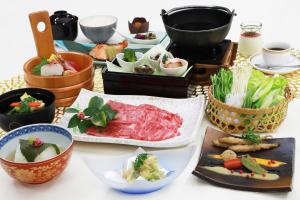 a table with various dishes of food on it at Hotel Binario Saga Arashiyama in Kyoto