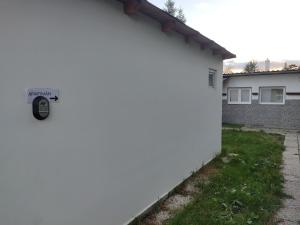 Una valla blanca con una puerta con un cartel. en Malý apartmán v Praze en Praga