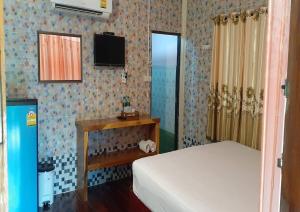 una camera da letto con un letto e una TV a parete di Noppakao Resort a Soem Ngam Altre 11 foto
