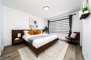 a bedroom with a large bed and a chair at Urban Zen, AirCon, King Bed, 10 min WEM & DT! in Edmonton