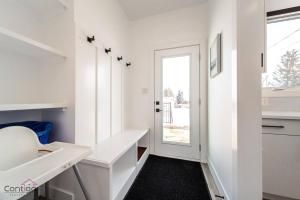 a white room with a white desk and a door at Urban Zen, AirCon, King Bed, 10 min WEM & DT! in Edmonton