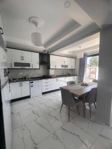 a kitchen with white cabinets and a table and chairs at Villa nightblue in Ortaca