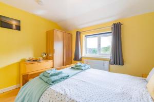 ein Schlafzimmer mit einem Bett mit blauen Handtüchern darauf in der Unterkunft Cornish Holiday - Meadow Rise in Saint Columb Major