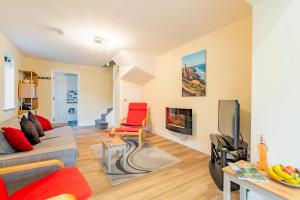 a living room with a couch and a tv at Cornish Holiday - Meadow Rise in Saint Columb Major