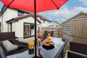 a table with a plate of food and two glasses of wine at Cornish Holiday - Meadow Rise in Saint Columb Major