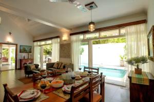 a living room with a table and a dining room at Aguada Anchorage - The Villa Resort, Candolim in Candolim