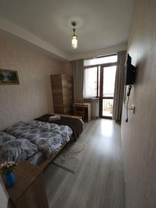 a bedroom with a bed and a television and a window at Hotel Tradicia in Tbilisi City