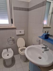 a white bathroom with a toilet and a sink at La casa di Federica in Spoleto +8 photos