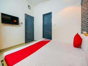 a bedroom with a bed with a red blanket at OYO Unique Delhi Home Stay in New Delhi