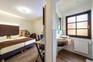 a hotel room with a bed and a sink and a desk at Landhaus Alte Scheune in Frankfurt/Main