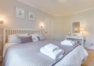 a bedroom with a white bed with towels on it at 12 New Street in Padstow