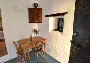 a small table with two chairs and a bottle of wine at The Gatehouse in Llanrwst