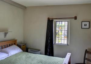 a bedroom with a bed and a window at The Gatehouse in Llanrwst
