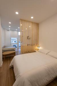 1 dormitorio con 1 cama blanca grande y bañera en A Madrid centro, metro 2 min a pie, en Madrid