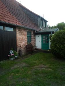 a house with a green door and a bench in the yard at Her - "Auf dem Käubs" 