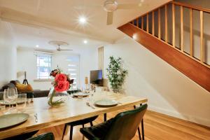 a dining room with a table and a staircase at Vibrant 3 Bedroom House Darlinghurst 2 E-Bikes Included in Sydney