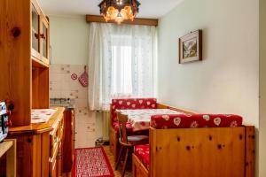 a kitchen with a table and chairs and a window at Appartamento Aurone in Arabba