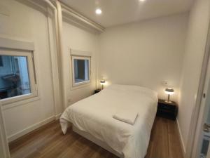 1 dormitorio con 1 cama blanca y 2 ventanas en A Madrid centro, metro 2 min a pie, en Madrid