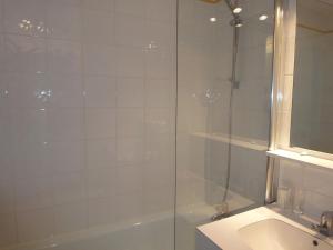 uma casa de banho com um chuveiro, uma banheira e um lavatório. em Majestic Apartment in Meribel Mottaret close to Skiing em Méribel