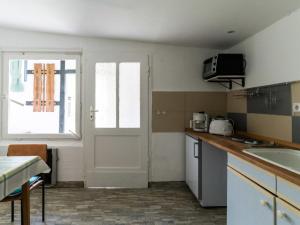 een keuken met een deur, een wastafel en een tafel bij Lake View Apartment in Klein Pravtshagen with Garden in Klein Pravtshagen