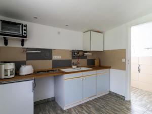 a kitchen with white cabinets and a microwave at Lake View Apartment in Klein Pravtshagen with Garden in Klein Pravtshagen