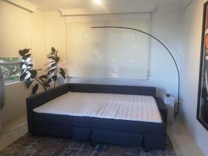 a bed in the corner of a room at Harbourside7 - modern 1br unit with fab views in Sydney