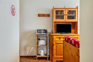 a living room with a tv and a desk with a television at Appartamento Aurone in Arabba +18 photos