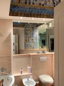 een badkamer met een toilet, een wastafel en een spiegel bij Appartamento di charme nel cuore di Chiavari in Chiavari