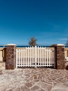 una cerca blanca con el océano en el fondo en Villa Petronilla sul mare, en Savelletri di Fasano