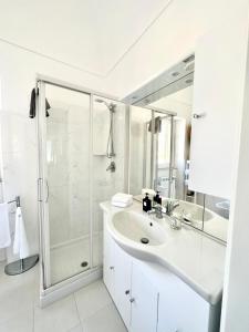 een witte badkamer met een douche en een wastafel bij LA CASA SUL MARE in San Vito Chietino