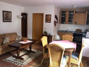 a living room with a table and a kitchen at Apartment in Bruchhausen right on the fishing river in Oberveischede