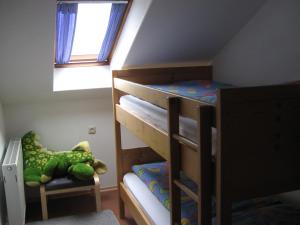 a bedroom with bunk beds with a dinosaur toy and a chair at Apartment in the Allg u with view of the Bavarian Alps in Bernbeuren
