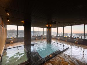 a swimming pool in a building with large windows at Mikuma Hotel in Hita