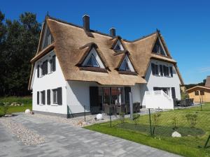 Cette grande maison blanche est dotée d'un toit de chaume. dans l'établissement Fairy tale holiday home in Rerik near the centre, à Rerik