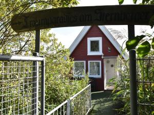 a red house with a fence in front of it at Striking Holiday Home in Sternberg with Jetty in Sternberg