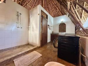 a bathroom with a shower and a sink and a toilet at Villa Twiga in Ukunda +33 photos