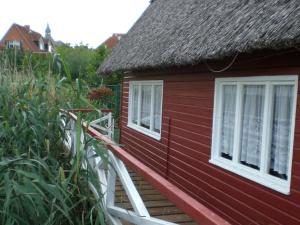a red house with white windows and plants at Striking Holiday Home in Sternberg with Jetty in Sternberg