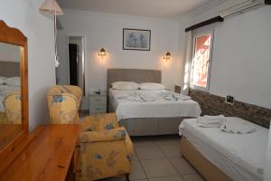 a hotel room with two beds and a table and chairs at Melis Pansiyon in Bodrum City