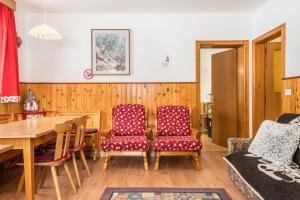een woonkamer met een tafel en 2 stoelen bij Samont Appartment 7 in Arabba