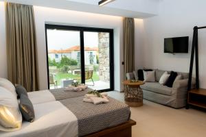 sypialnia z łóżkiem, kanapą i oknem w obiekcie Niki Luxury Apartments Niki Suites Petra w Pétrze