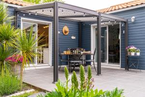 une pergola sur une terrasse avec une table dans l'établissement Escale et bien-être, à Pornic