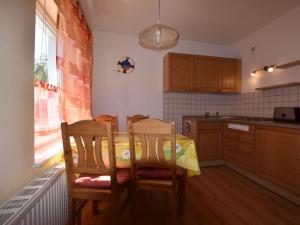 a kitchen with a table and two chairs in it at Spacious Apartment in Wieck auf dem DarB in Wieck