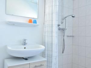 a white bathroom with a sink and a shower at Spacious Apartment in Wieck auf dem DarB in Wieck