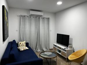 sala de estar con sofá azul y TV en Lilian apartment, en Ayia Napa