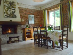 a dining room with a table and a fireplace at Holiday home in a historic building near Montreuil in Gouy-Saint-André