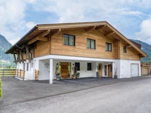 a large wooden house with a garage at Apartment building Ferien, Neukirchen in Rosenthal