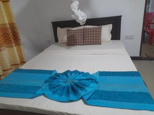 a bed with two blue towels on it at The Cozy Cottage Habarana in Habarana