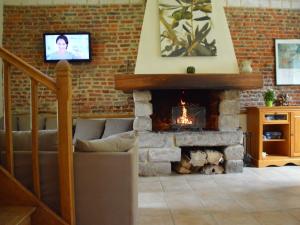 a living room with a fireplace and a tv at Holiday home in a historic building near Montreuil in Gouy-Saint-André