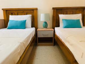 2 nebeneinander sitzende Betten in einem Schlafzimmer in der Unterkunft Beach House - Seaview Holiday Home in Marsalforn